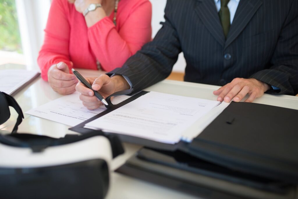a person s hand holding a pen near a piece of paper
